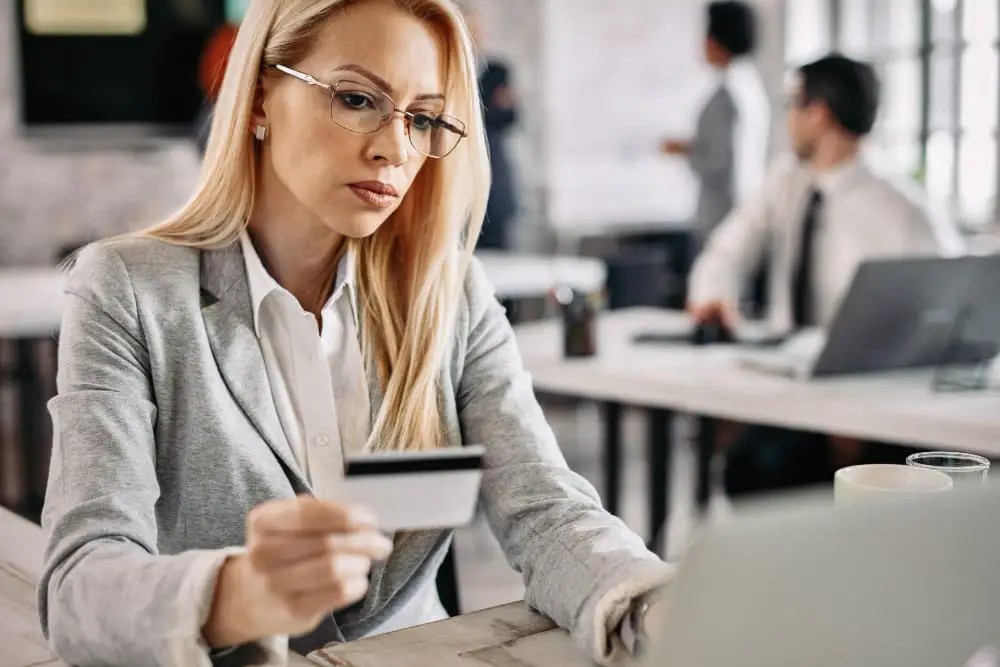 biznesowa kobieta patrzy na kartę kredytową